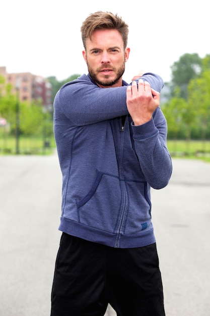 Mannelijke atleet buiten doen rek