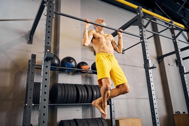 Mannelijke atleet die pull-ups doet in de sportschool