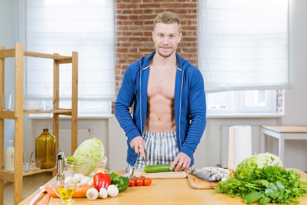 Mannelijke atleet gezonde voeding thuis in de keuken bereiden