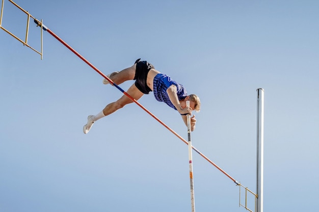 Mannelijke atleet paaltje op blauwe achtergrond