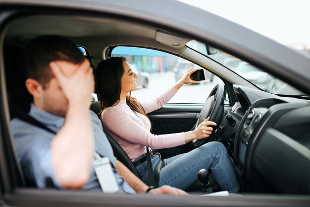 Mannelijke auto-instructeur neemt examen in jonge vrouw