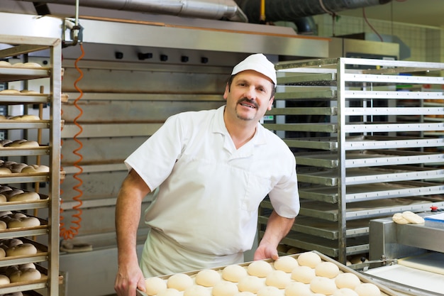 Mannelijke bakker broodjes bakken