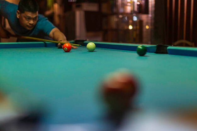 Mannelijke bal spelen snooker biljartspeler met keu gericht