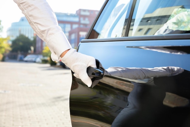 Mannelijke bediende die autodeur opent