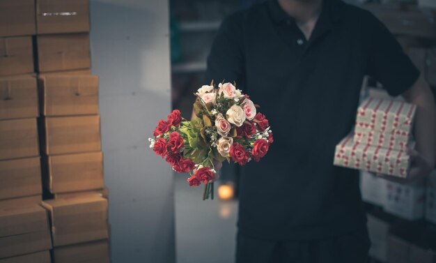 Mannelijke bedrijfseigenaar die de bestelling inpakt voor verzending naar de verpakkingsdoos van de klant voor levering