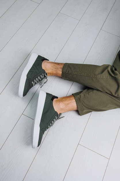 Mannelijke benen in broek en groene casual sneakers Modieuze herenschoenen