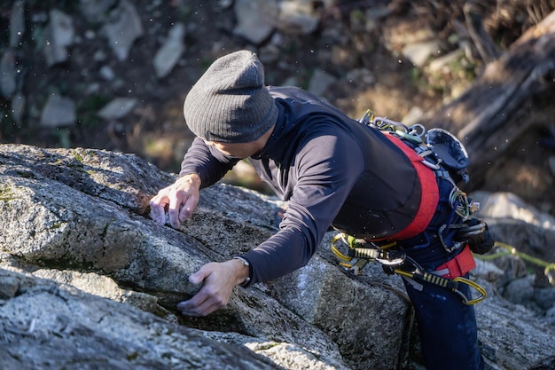 Mannelijke bergbeklimmer klimmen op de rand van de klif