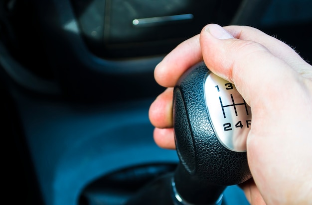 Foto mannelijke bestuurder die met de hand versnellingen verschuift, een man die een auto bestuurt