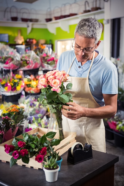 Mannelijke bloemist die bloemen schikt