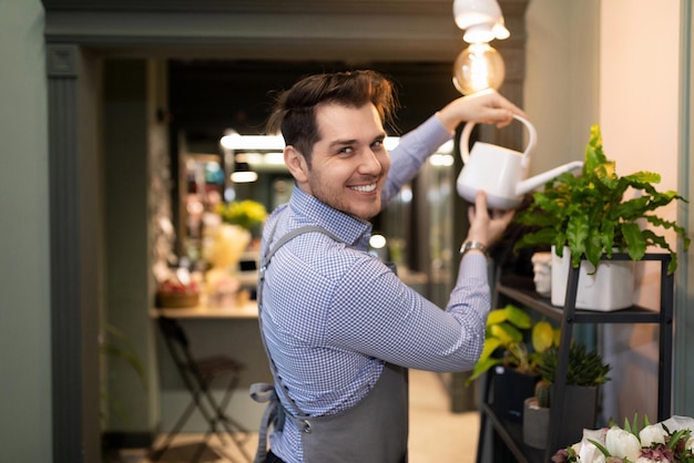 Mannelijke bloemist die potplanten water geeft uit een gieter