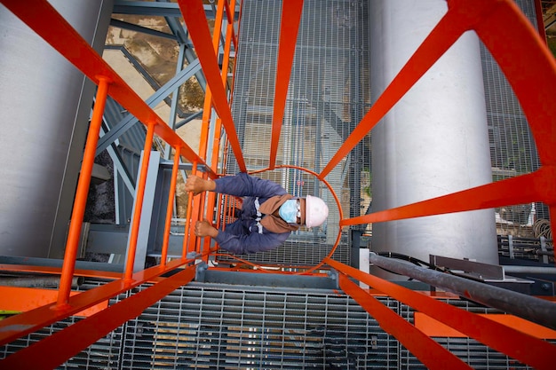 Mannelijke bovenaanzicht beklim de trap steigers inspectie pijpleiding olie- en gaspetrochemie-industrie