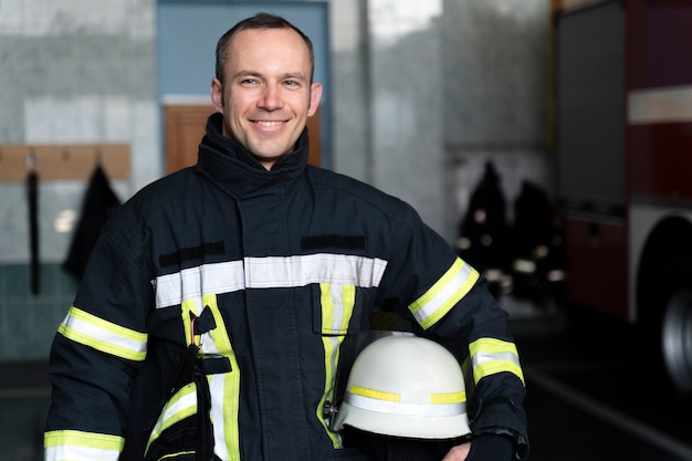 Mannelijke brandweerman poseren met pak en helm