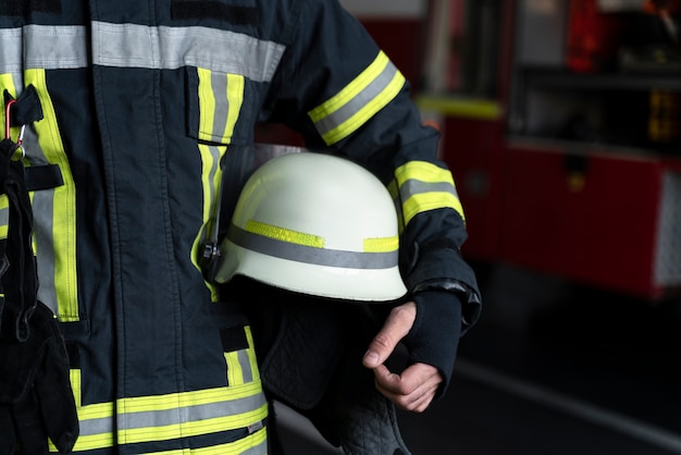 Foto mannelijke brandweerman poseren met pak en helm