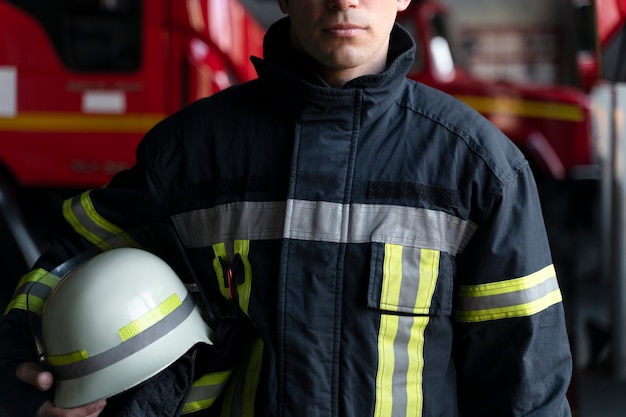 Foto mannelijke brandweerman poseren met pak en helm