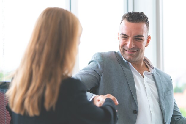 Mannelijke chef-handshake met vrouwelijke werknemer voor succes