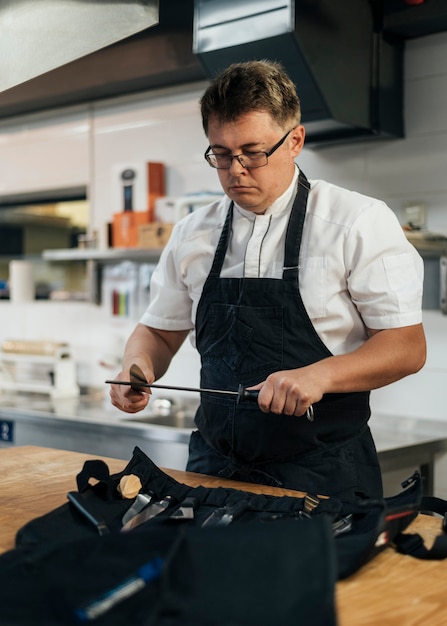 Foto mannelijke chef-kok die klembord in de keuken controleert