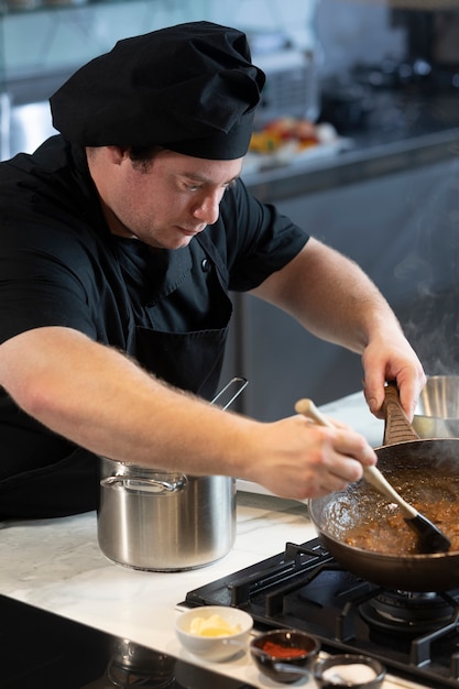 Foto mannelijke chef-kok in de keuken koken