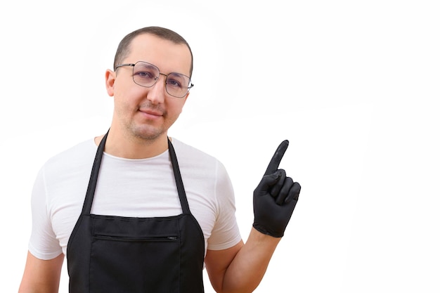 Mannelijke chef-kok in een schort op een witte achtergrond die met zijn vinger wijst naar de lege ruimte voor menutekst