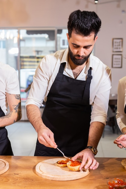 Mannelijke chef-kok kokende hamburger in restaurantkeuken