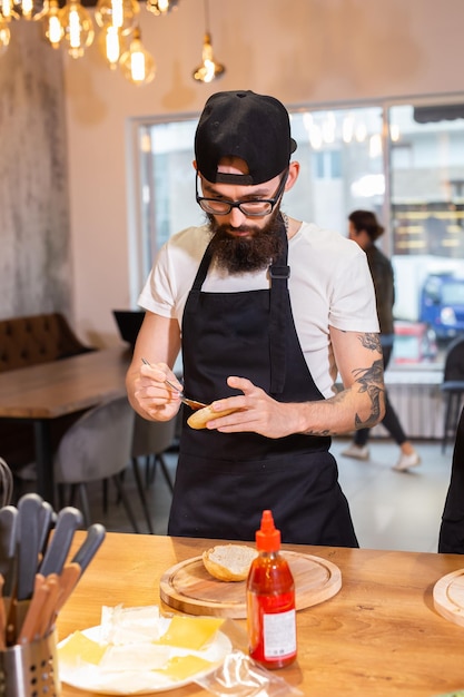 Mannelijke chef-kok kokende hamburger in restaurantkeuken