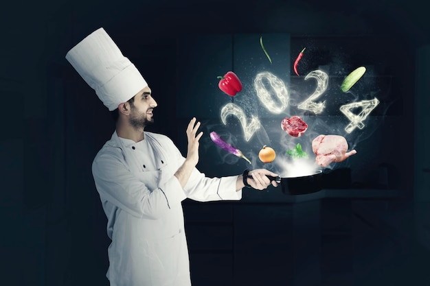 Mannelijke chef-kok met nieuwjaarsnummers voor 2024