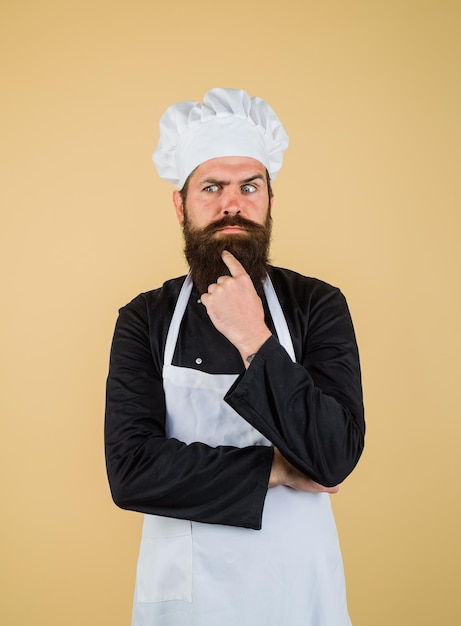 Mannelijke chef-kok of bakker in uniform denken wat te koken denkende chef-kok die nieuw menu kookt