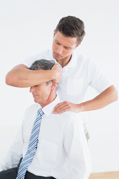 Mannelijke chiropractor die halsaanpassing doet