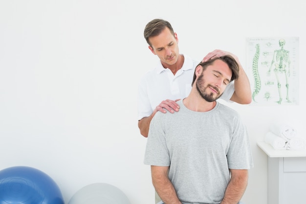 Mannelijke chiropractor die halsaanpassing doet