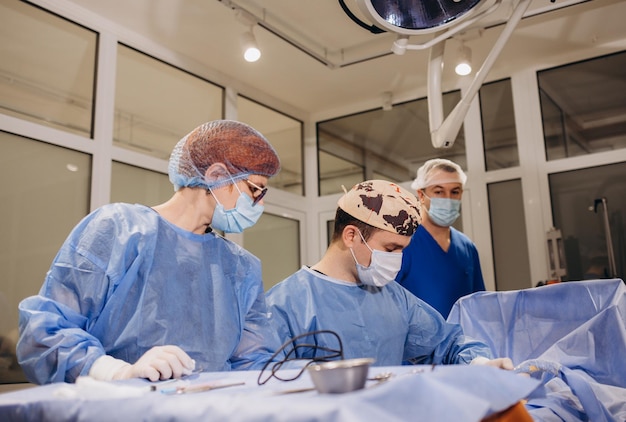 Mannelijke chirurg met een beschermkap en masker die staat en de operatie voorbereidt Medic tijdens de operatie Medicijnconcept