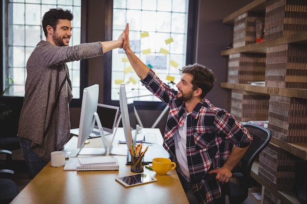 Mannelijke collega's hoge fiving in office