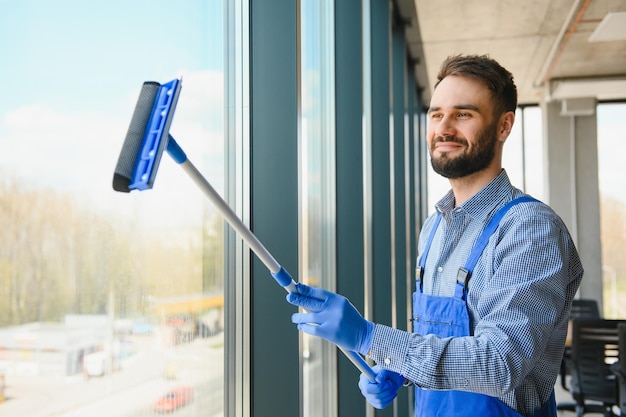 Mannelijke conciërge schoonmaak raam in kantoor