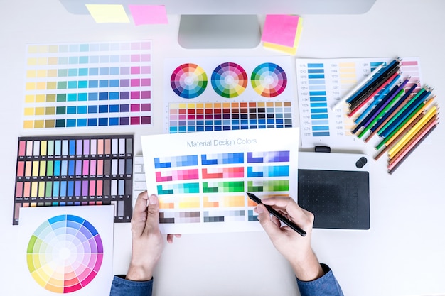 Mannelijke creatieve grafische ontwerper die aan kleurselectie en kleurenmonsters werkt