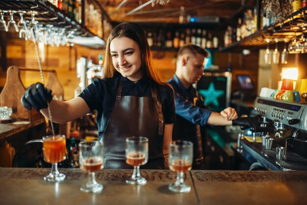 Mannelijke en vrouwelijke barman aan de toog