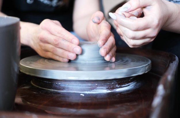 Mannelijke en vrouwelijke handen maken een vaas van klei Datum in de werkplaats Horizontale foto
