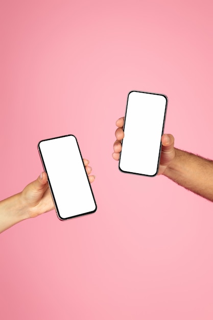Mannelijke en vrouwelijke handen tonen mobiele telefoons met een wit scherm