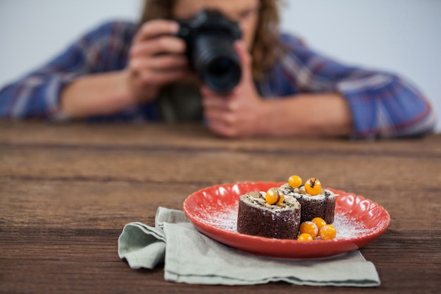 Mannelijke fotograaf die voedsel fotografeert