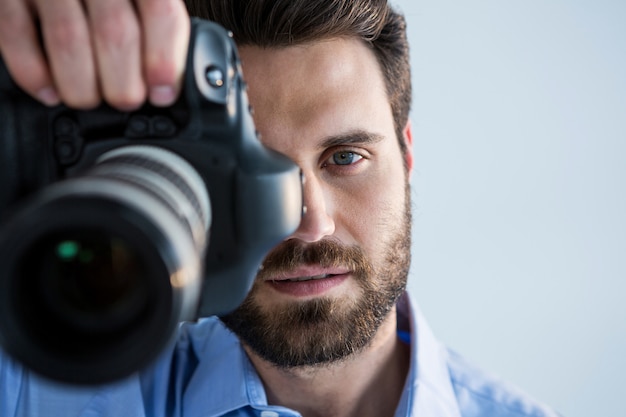 Mannelijke fotograaf met digitale camera in de studio