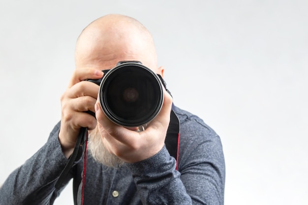 mannelijke fotograaf met een camera in zijn handen op een witte achtergrond
