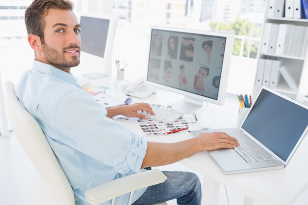 Mannelijke fotoredacteur die aan computer werkt