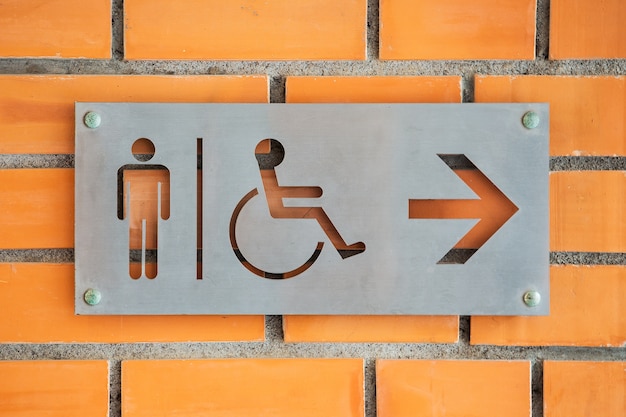 Mannelijke gehandicapte persoon Toilet Label op rode bakstenen muur