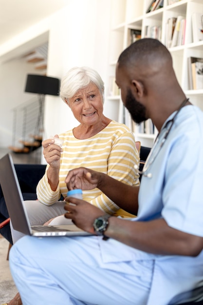 Mannelijke gezondheidswerker met digitale tablet die met blanke senior vrouw bespreekt over medicatiedosis