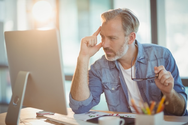 Mannelijke grafisch ontwerper werkt op de computer