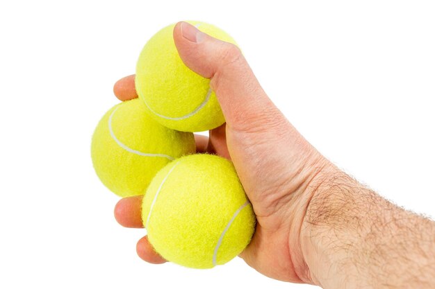 Mannelijke hand houdt drie gele tennisballen geïsoleerd op een witte achtergrond