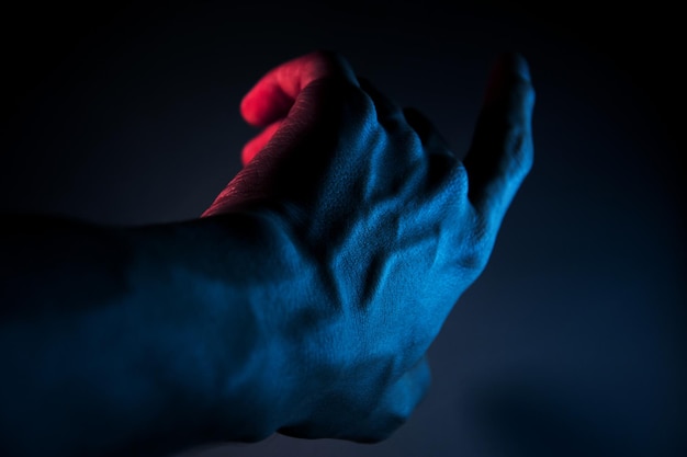 Foto mannelijke hand verlicht met blauw licht