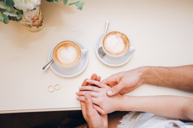 Mannelijke handen houden vrouwelijke handen. vrouwelijke hand met een trouwring. betrouwbare mannelijke handen. sterke mannelijke handen.