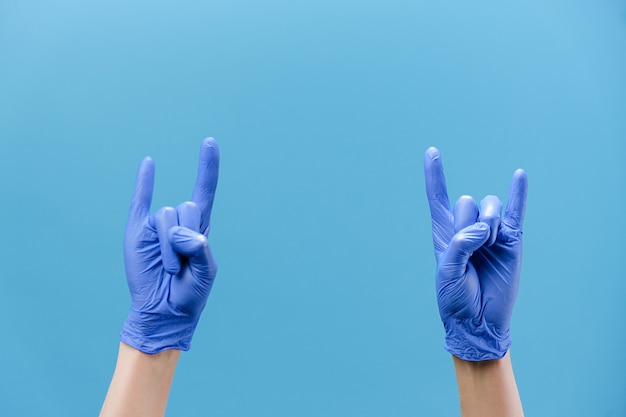 Mannelijke handen in handschoenen zwaaien met hoorns gebaar