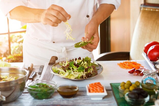 Mannelijke handen maken salade.