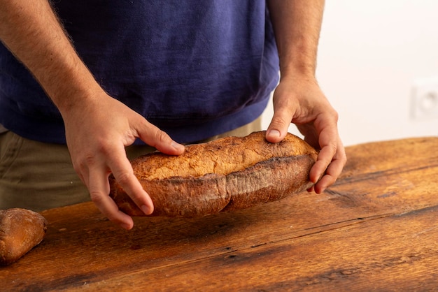 mannelijke handen met brood over houten oppervlak