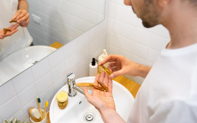 Mannelijke handen met cosmetische ampullen met serum voor herstel van de haargroei schoonheid haar in een moderne lichte badkamer concept haaruitval het probleem van mannelijke kaalheid levensstijl