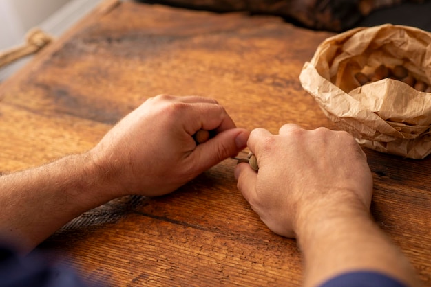 Foto mannelijke handen met hazelnoten over houten oppervlak
